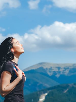 Long hair brunette girl on the top of the mountain enjoying fresh air